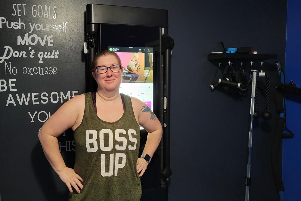 KerryAnn Lussier smiling next to her Tonal.