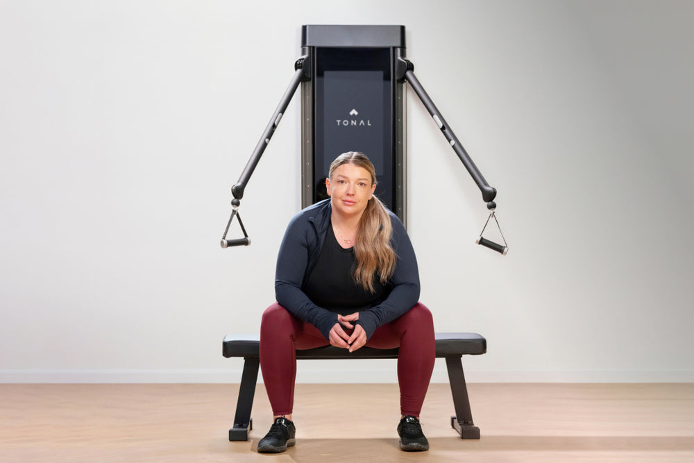 Megan Redmond sits on a bench in front of Tonal.