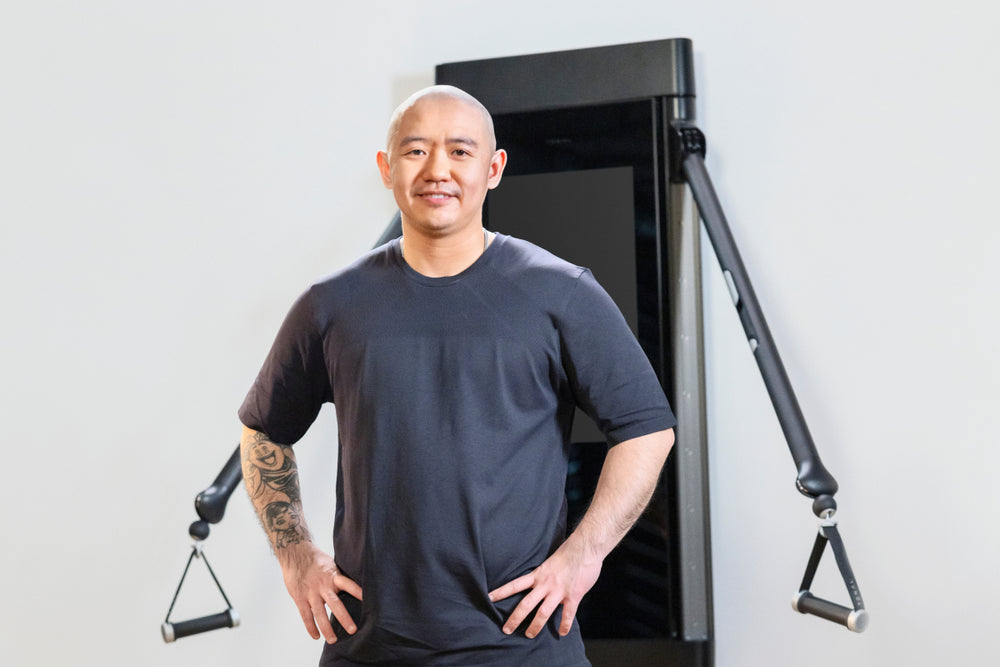 Xiaomin Xue smiling in front of Tonal.