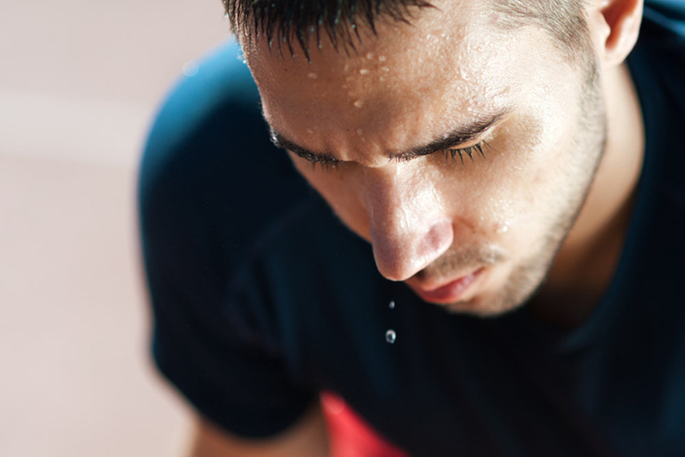 Close-up of a man sweating out electrolytes after a workout