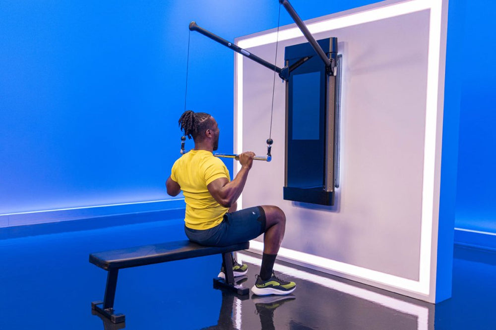 Tonal coach Ackeem Emmons doing a seated barbell lat pulldown