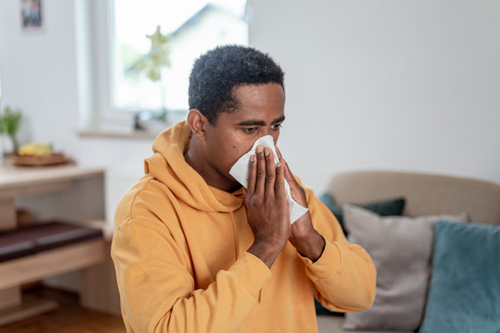 Man in workout clothes blowing his nose.