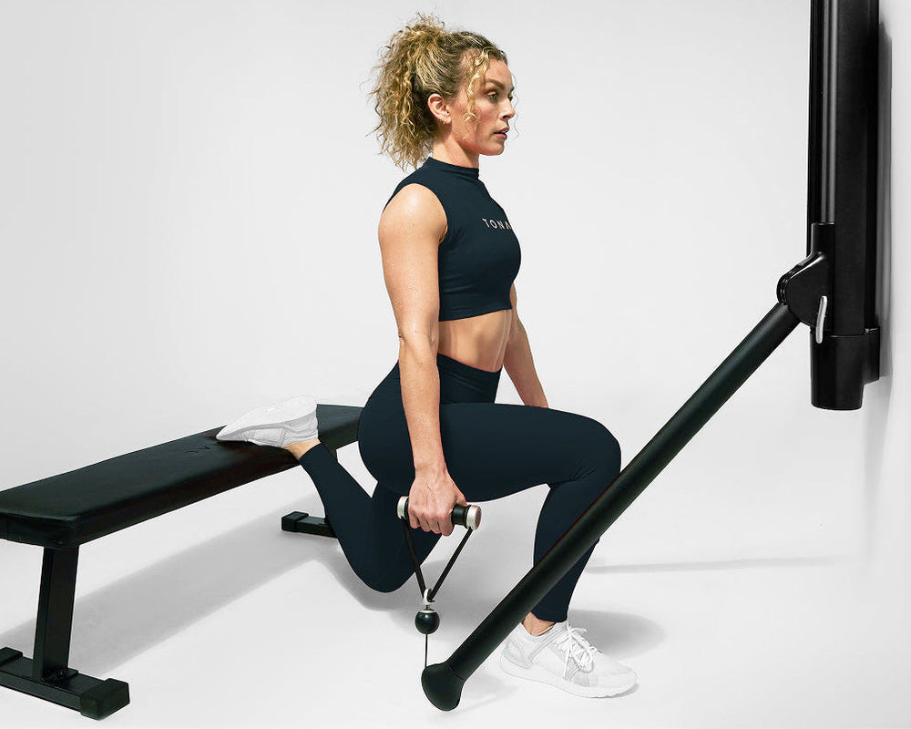 Woman performing a Bulgarian split squat with Tonal.