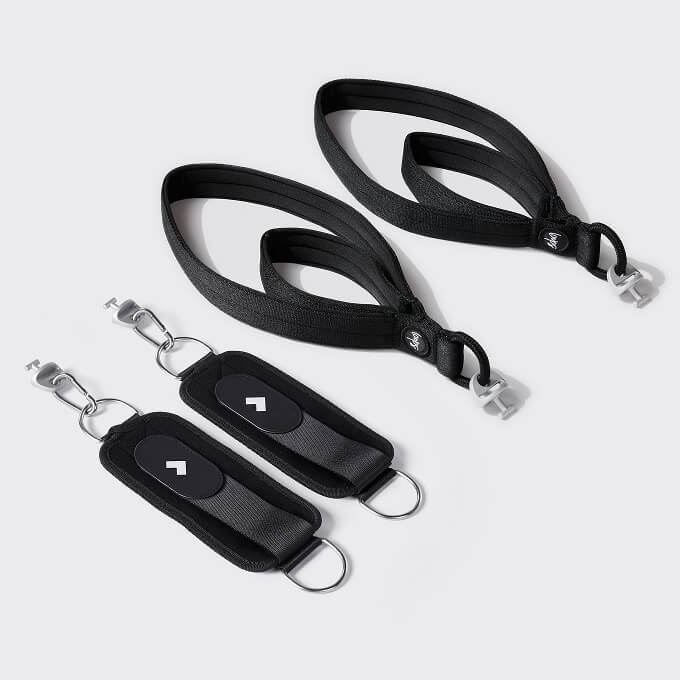 A pair of Tonal Pilates straps next to Tonal Ankle Straps