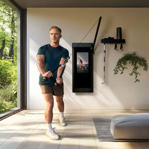 Man exercising with Tonal Rope on Tonal 2 in a room with large windows showing greenery outside.