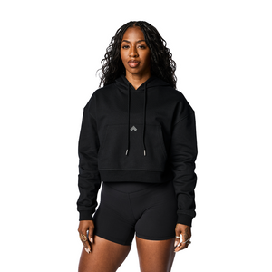 Woman wearing black cropped Tonal performance hoodie.