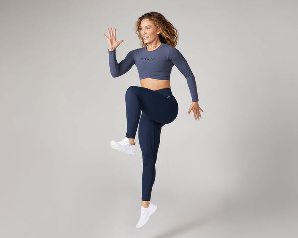 Tonal Coach Kendall Wood doing high knees as part of a plyometric workout.