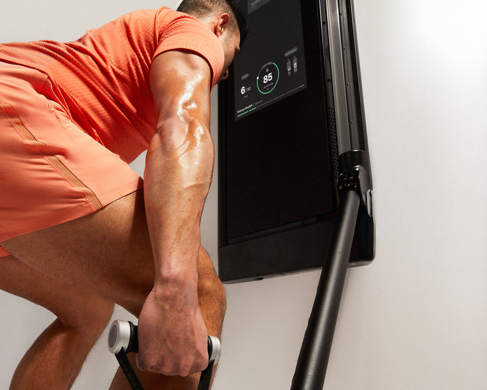 Tonal Coach Tim performing a suitcase deadlift to exercise his butt