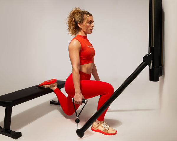 Tonal Coach Kendall Wood performing a Bulgarian split squat.