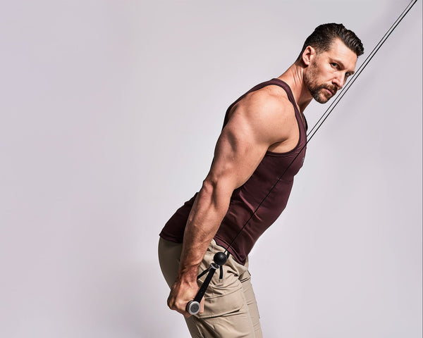 Tonal Coach Joe Rodonis performing a tricep kickback with Smart Handles.