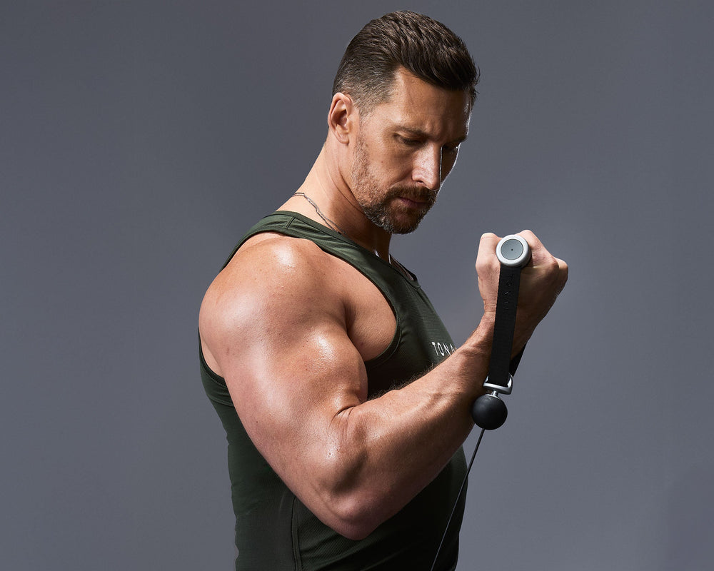 Tonal Coach Joe Rodonis performing a seated bicep curl.