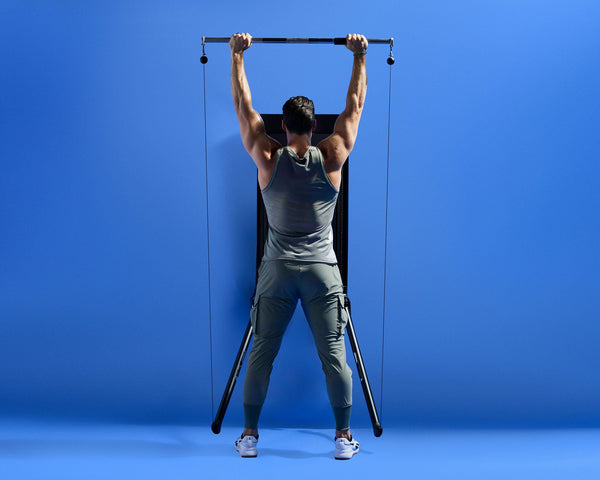 Tonal coach Joe Rodonis performing a barbell overhead press.