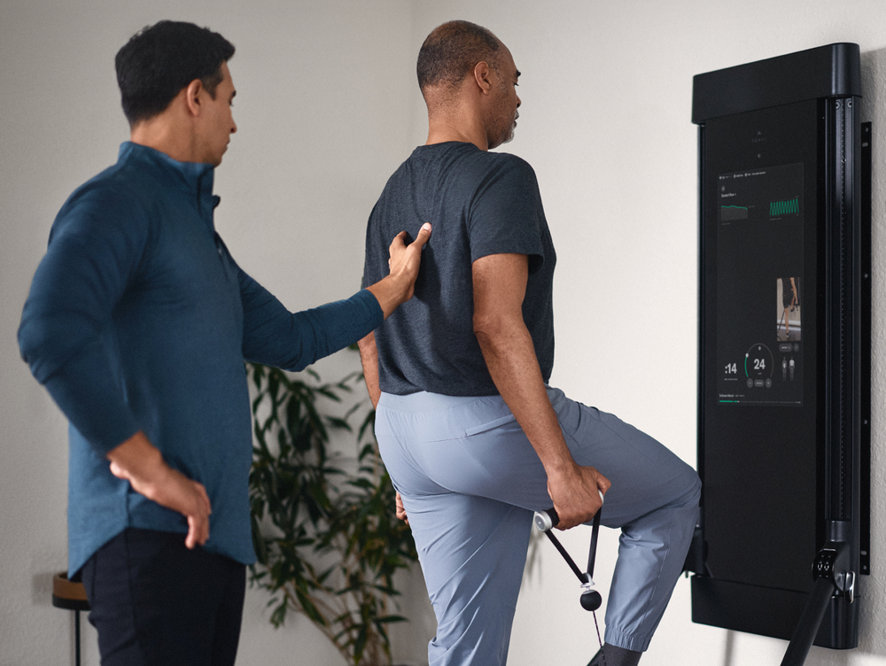 Two men interacting with a digital display in a modern setting