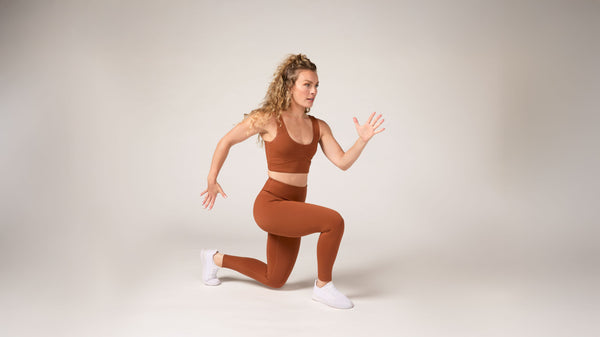 Tonal Coach Kendall Woody holding a split squat as part of an isometric workout.