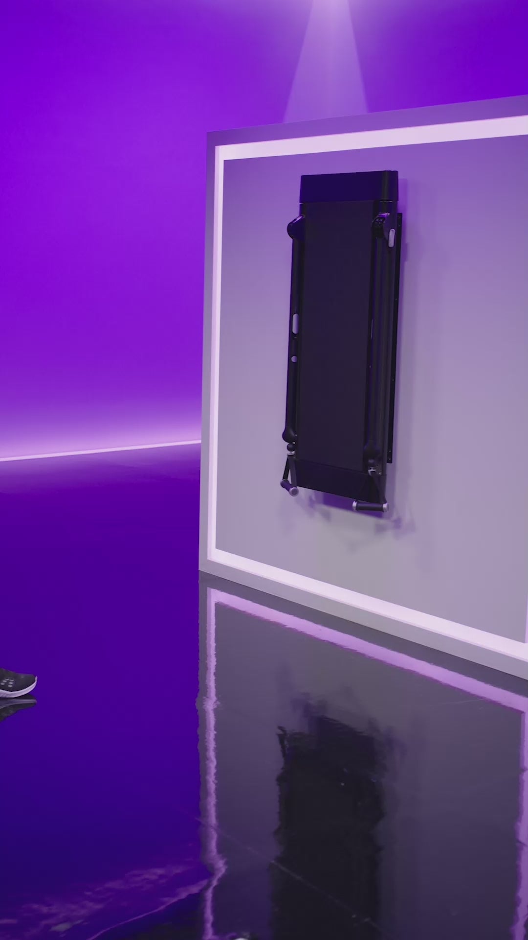 A woman stands facing away from Tonal with her arms extended in front of her and Smart Handles in each hand. She opens her arms outwards,  and brings them forward once more. 