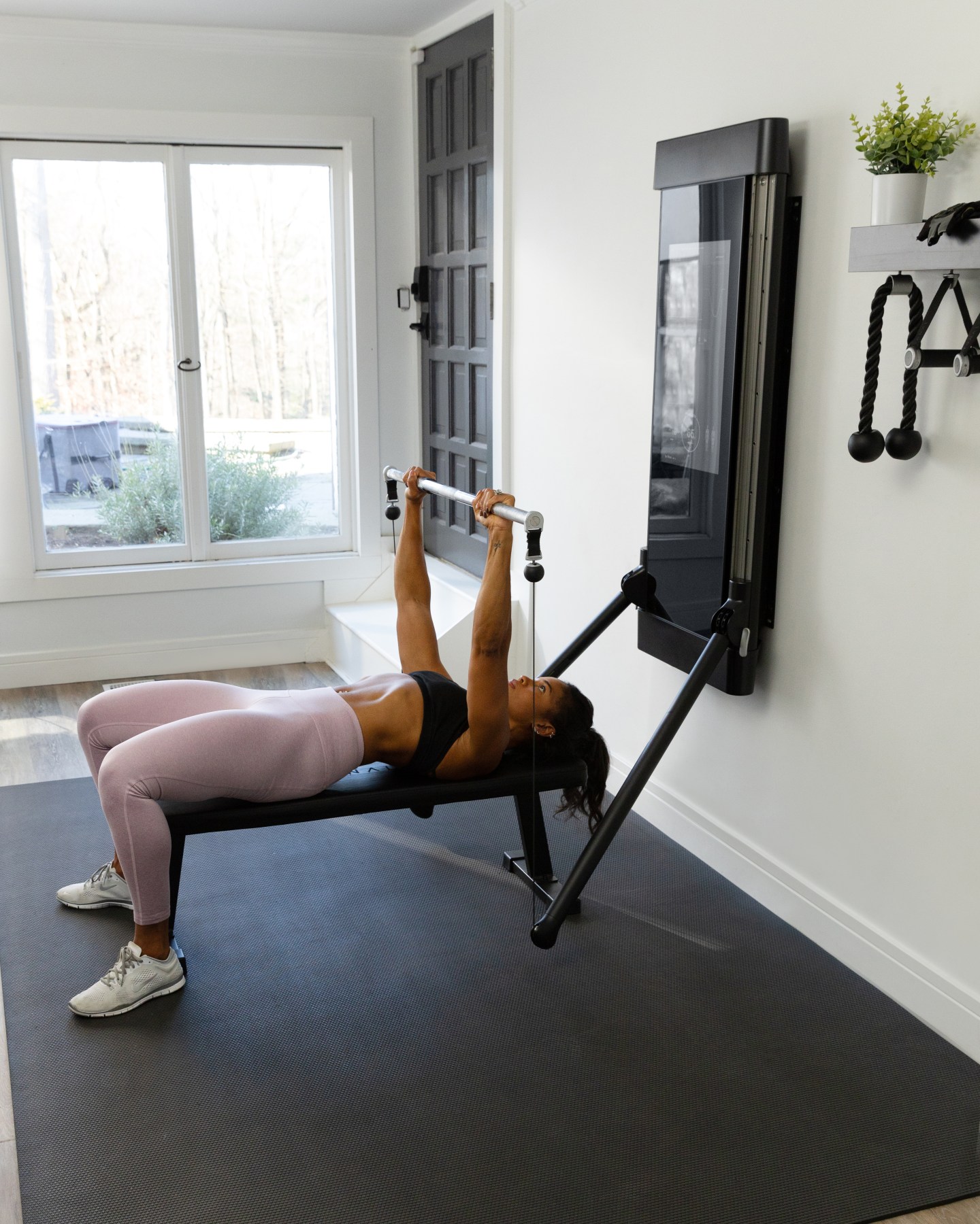 Michelle Tee performing a bench press on Tonal.