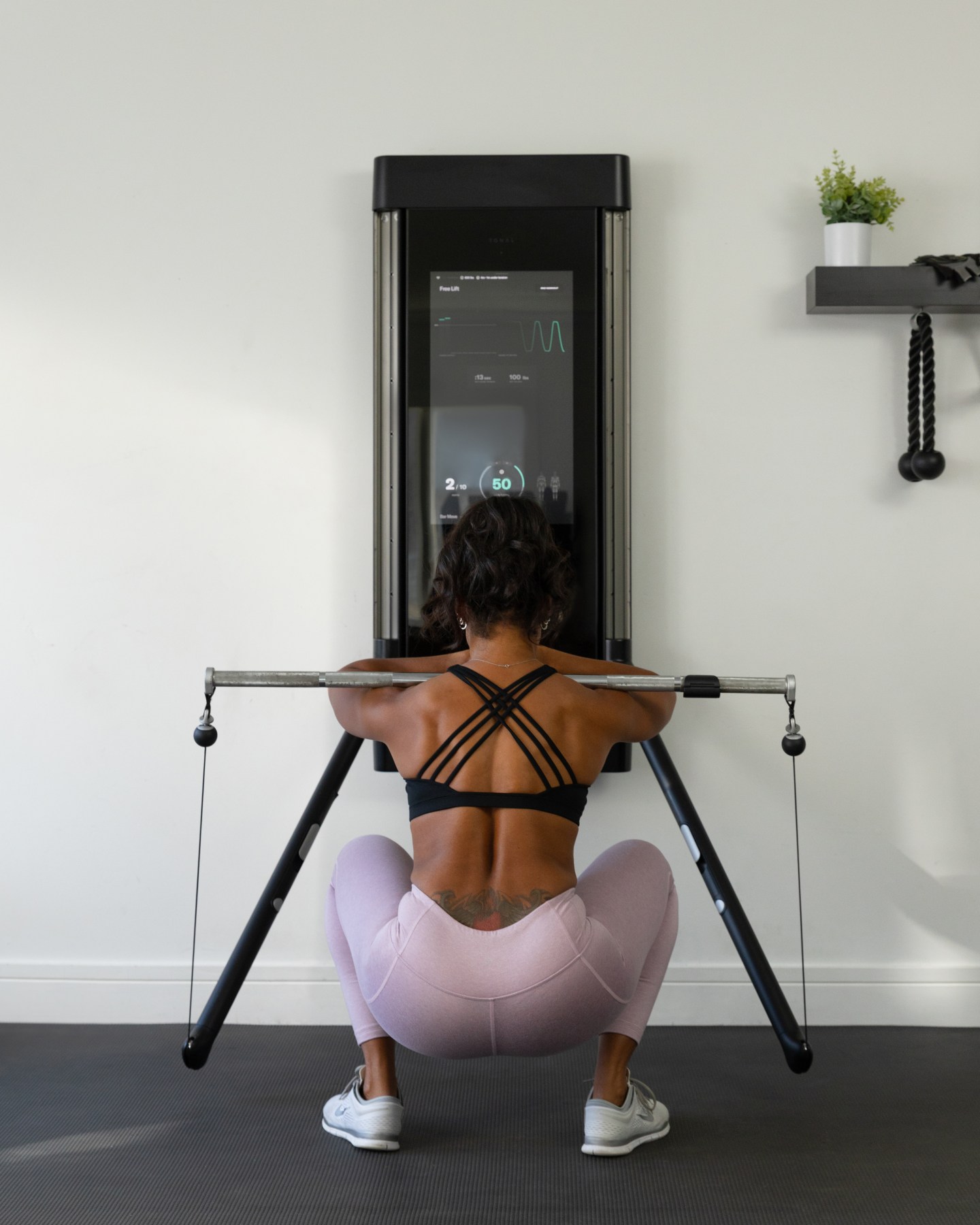 Michelle Tee performing a barbell squat on Tonal. 