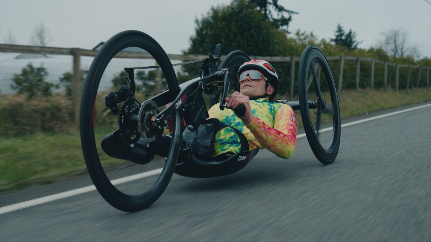 Travis Gaertner riding his handcycle through the street. 